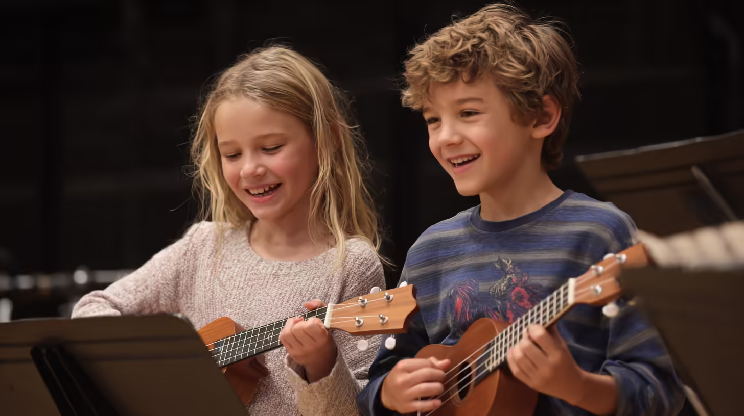 Happy kids laughing during a group ukulele lesson at K&M Music Company