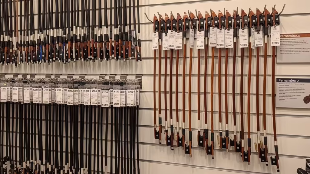 Store wall displaying many violin bows at different price levels
