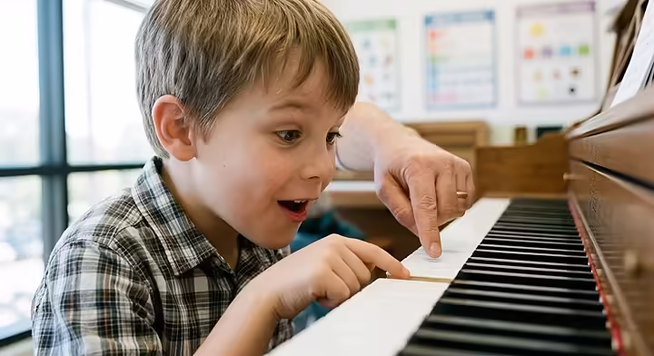 Child playing first notes during a beginner piano lesson