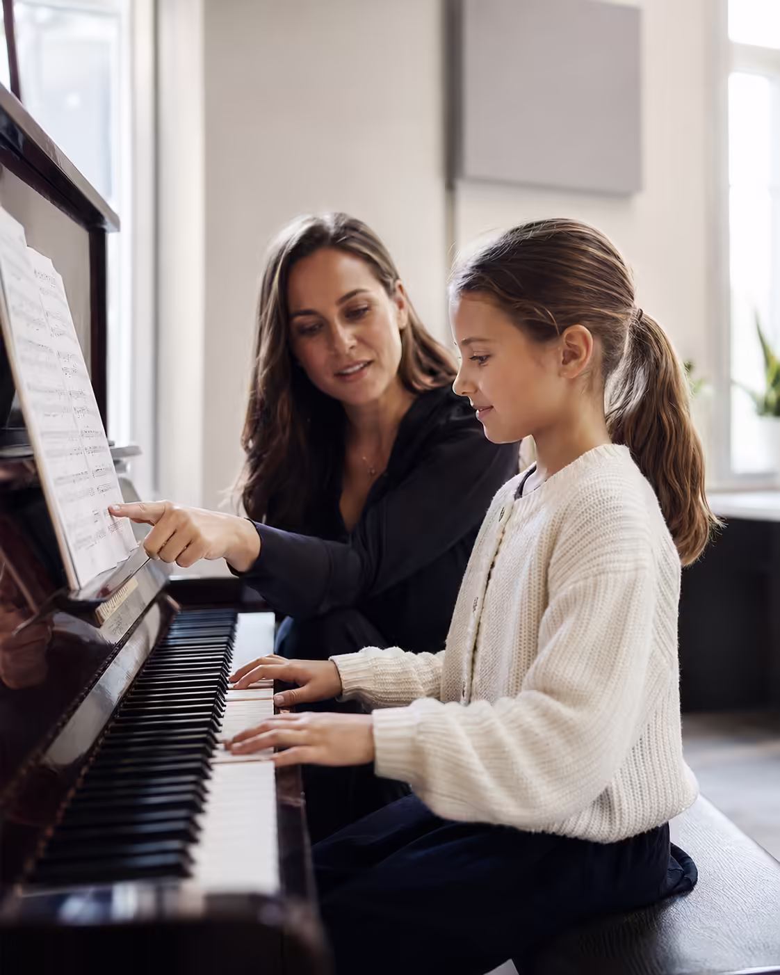 Beginner acoustic piano lesson with teacher demonstrating proper key technique